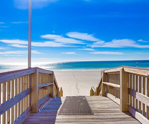 A wooden boardwalk leading to a beach with a clear blue sky. - Crystal Shores - Beachfront 2BR, Gulf Front Views, Indoor/Outdoor Pool, Hot Tub (Gulf Shores)