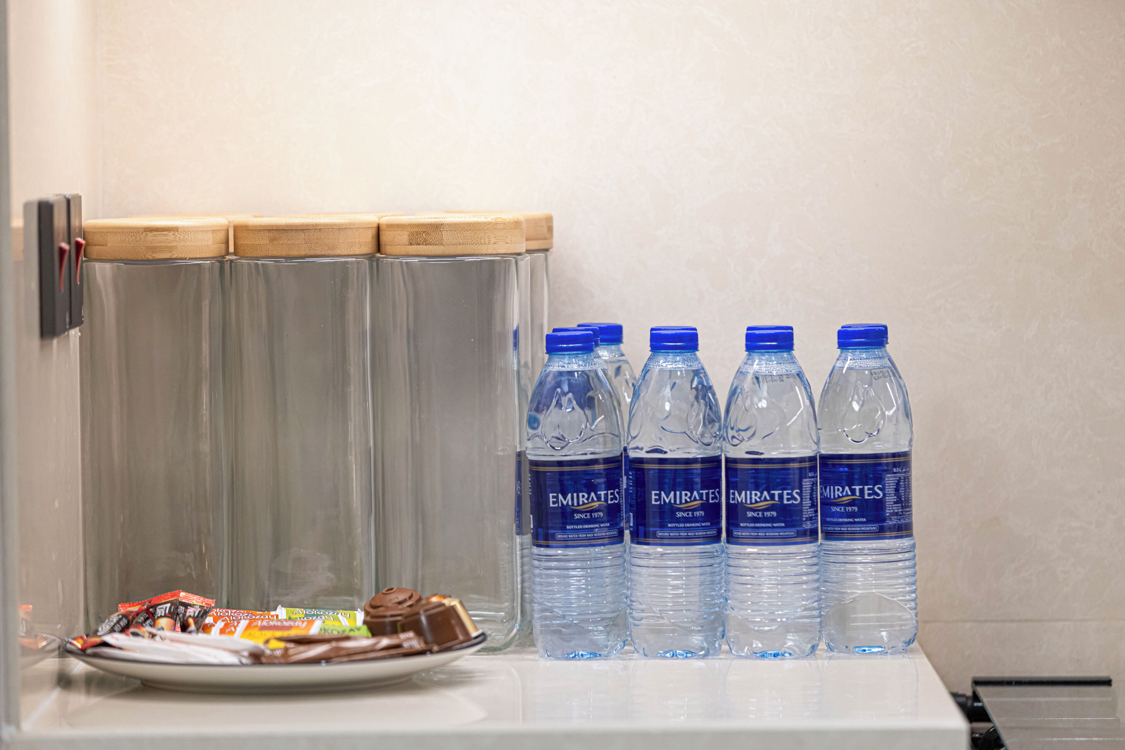 A refrigerator with bottled water and chocolate bars.