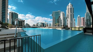 A swimming pool with a cityscape view, including high-rise buildings and a clear sky. - The Burj Crown Stays by UniDwellers Holiday homes (Dubai)
