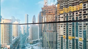 A high-rise building with multiple floors, a construction site in the foreground, and other high-rise buildings in the background. - The Burj Crown Stays by UniDwellers Holiday homes (Dubai)