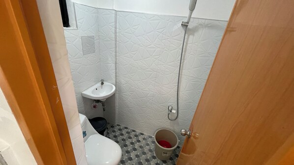 A small bathroom with a toilet, sink, and shower. - VillaMar Resort by Hiverooms (Medellin)
