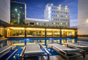 A hotel pool area with lounge chairs and a building in the background. - Palette Bangkok Airport Hotel (Bangkok)
