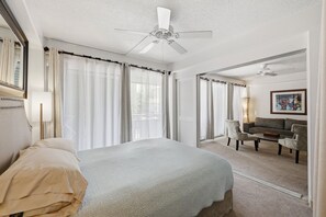 A hotel room with a bed, a ceiling fan, a sofa, and a coffee table. - Waikiki Oasis: Steps to Sand & Pool Hawaiian King (Honolulu)