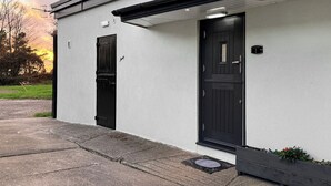 A modern building with a black door and a small porch area.