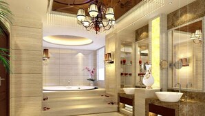 Een luxe badkamer met een groot bad, dubbele wastafels en een decoratieve spiegel.