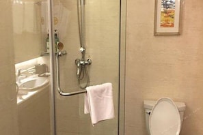 A bathroom with a glass shower enclosure, a white sink, and a toilet. - Blue Horizon International Hotel (Weifang)