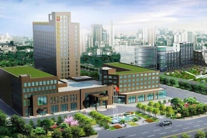A modern building with a green roof, large windows, and a flagpole. - Blue Horizon International Hotel (Weifang)