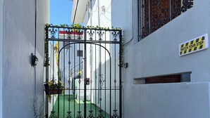 Un carrer estret amb una entrada reixa, uns quants escalons i un senyal que diu 'WATCH YOUR STEP'.
