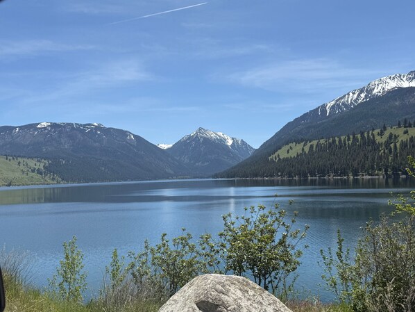 Un lac entouré de montagnes, sous un ciel dégagé.
