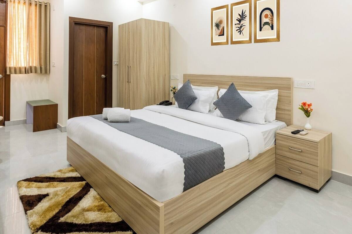 A modern bedroom with a large bed, a ceiling fan, and a wooden wardrobe.