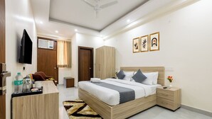Una habitación de hotel moderna con una cama grande, muebles de madera, un televisor de pantalla plana y obras de arte en la pared.