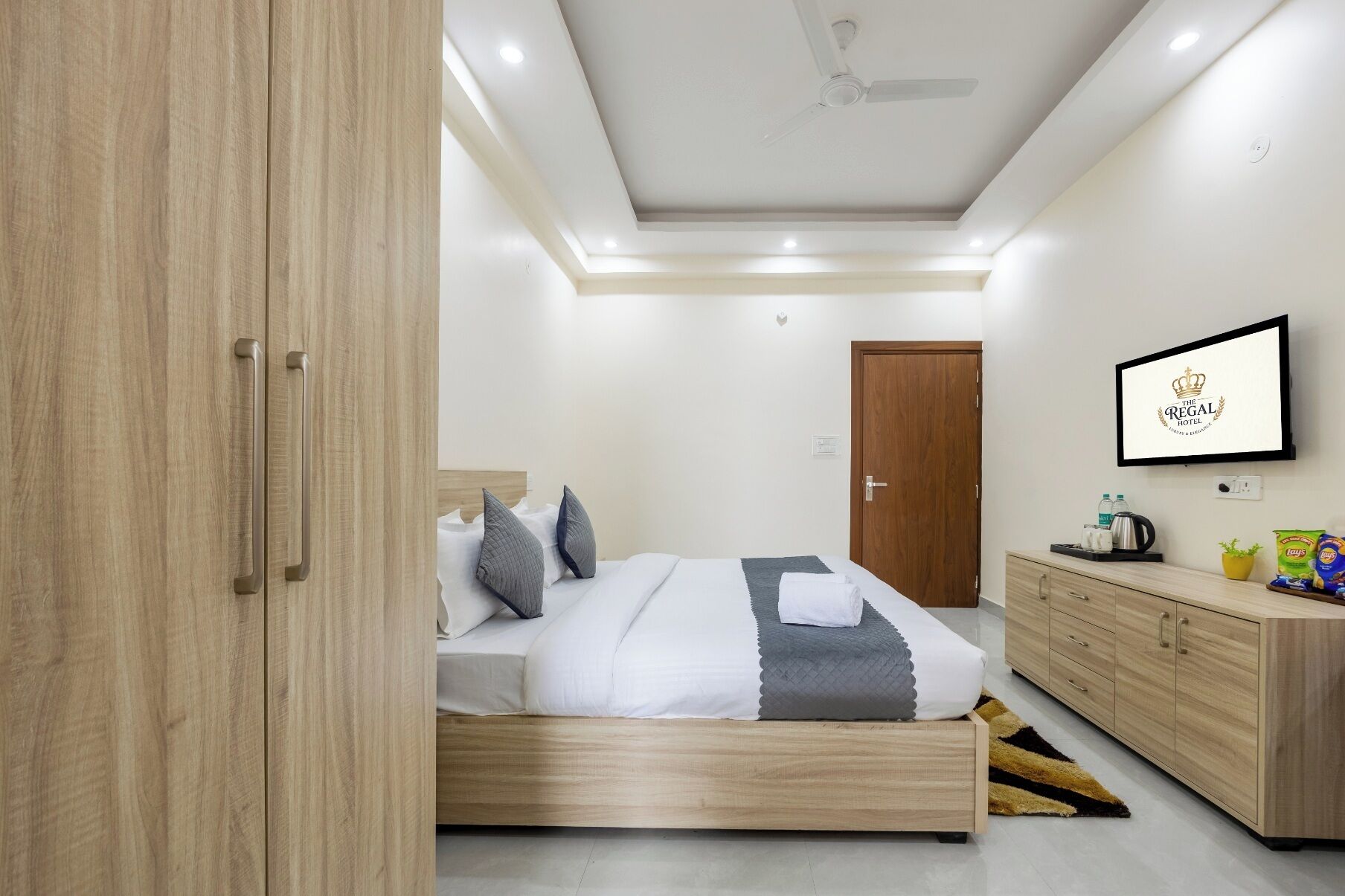Un dormitorio moderno con cama, mesita de noche, armario y ventilador de techo.