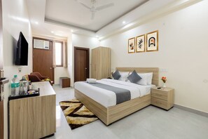 Een moderne hotelkamer met een houten bed, een bureau, een stoel en een televisie.