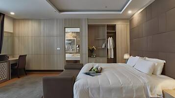 A modern hotel room with a large bed, a desk, and a walk-in closet.