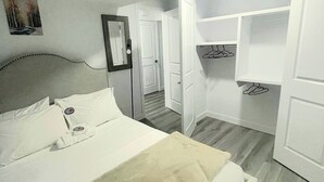 A bedroom with a bed, a wardrobe, and a mirror. - A Place of Refuge and Comfort (Edmonton)