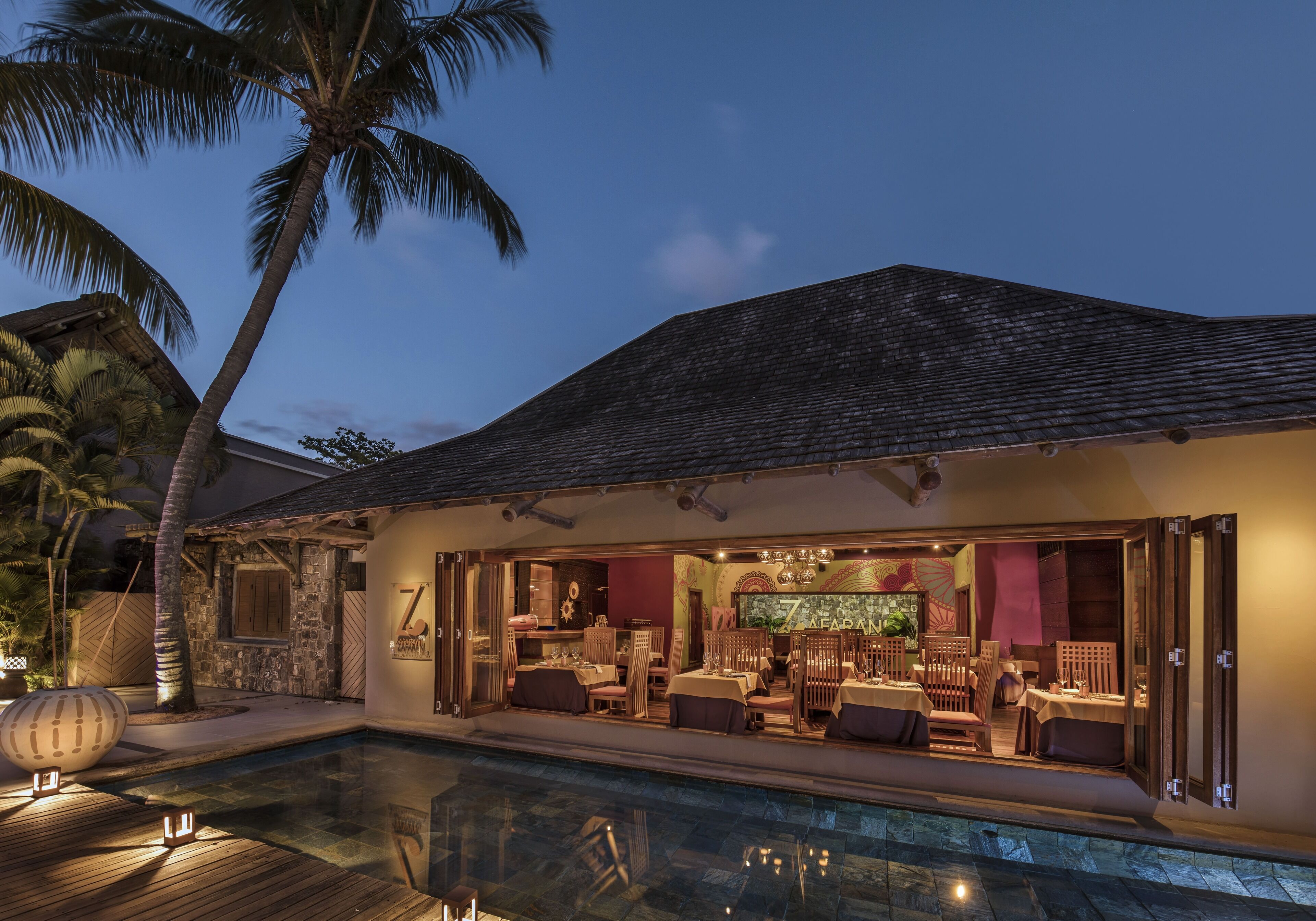 Ein Resort mit Pool, Sitzgelegenheiten im Freien und einer Bar.