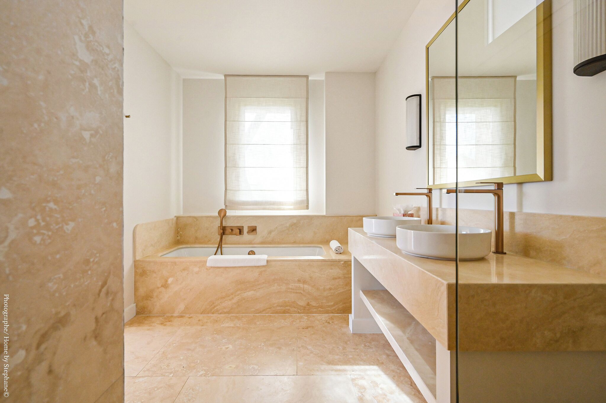 Un bany modern amb banyera, un mirall gran i un lavabo amb rentapès.
