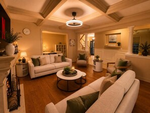 A spacious living room with a fireplace, a sofa set, a coffee table, and a dining area. - Poolside 4BR by Canterra Stays · Sleeps 12 (Brampton)