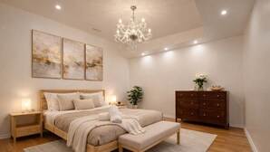 A bedroom with a wooden bed, bedside tables, a bench, a dresser, and a chandelier. - Two Independent Suites · Two Entrances · Sleeps 8 · Fireplace + Sun-Filled Upper Unit (Brampton)