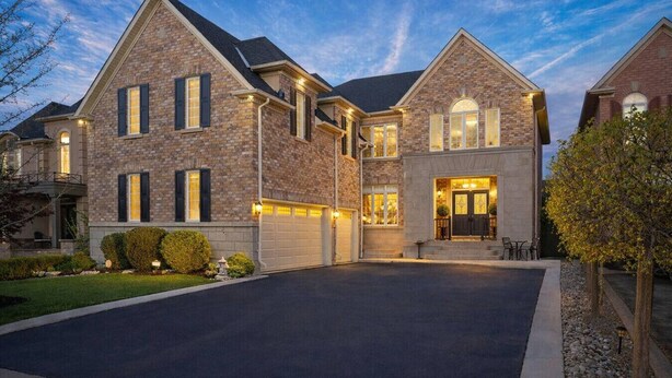 A two-story brick house with a garage, a well-maintained lawn, and a driveway. - Two Independent Suites · Two Entrances · Sleeps 8 · Fireplace + Sun-Filled Upper Unit (Brampton)
