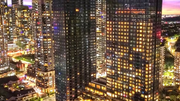 Un immeuble de grande hauteur, doté de nombreux étages, de grandes fenêtres et d’une façade bien éclairée.