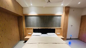 Una camera da letto moderna con un letto, pannelli in legno, una ventola a soffitto e un comodino.