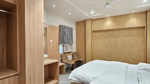 Una camera da letto moderna con un'armadiatura in legno, un letto, una scrivania e una sedia.