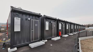 A row of industrial-style buildings with numbered doors, likely serving as storage or utility units.