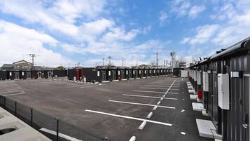 A parking lot with multiple rows of parking spaces and a row of portable toilets.
