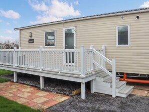 A mobile home with a white deck, a small staircase, and a nameplate on the wall. - Keswick 17 - UK51391 (Narberth)