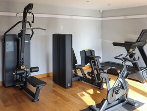 A gym with exercise equipment including a bench, weight machine, and elliptical. - Keswick 17 - UK51391 (Narberth)