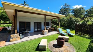 A modern house with a covered patio, stone seating, a fire pit, and a pool area. - Cabin One- Sauna, pet-friendly, adults only (Lowanna)