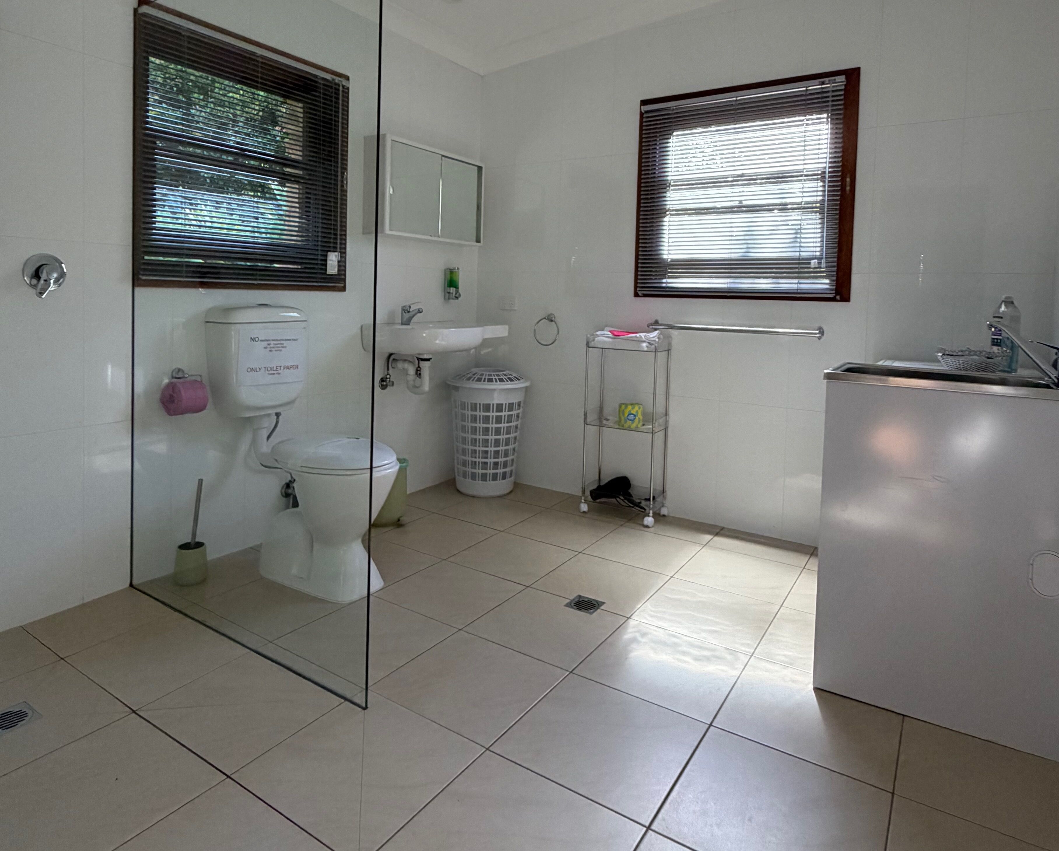 Een badkamer met toilet, wastafel en spiegel.