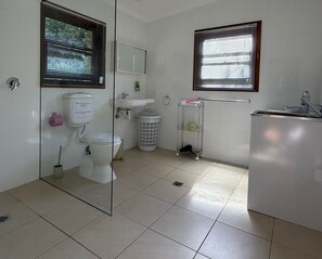 Un baño con inodoro, lavamanos y espejo.