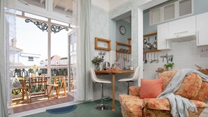 A living room with a sofa, a dining area with a table and chairs, and a kitchen with cabinets and utensils. - 1 bedroom accommodation in Paignton (Paignton)