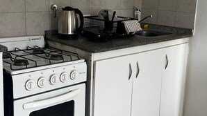 A kitchen with a white stove, oven, and cabinets, a granite countertop, and a tiled backsplash. - Apartment in the middle of the city Córdoba Argentina (Córdoba)