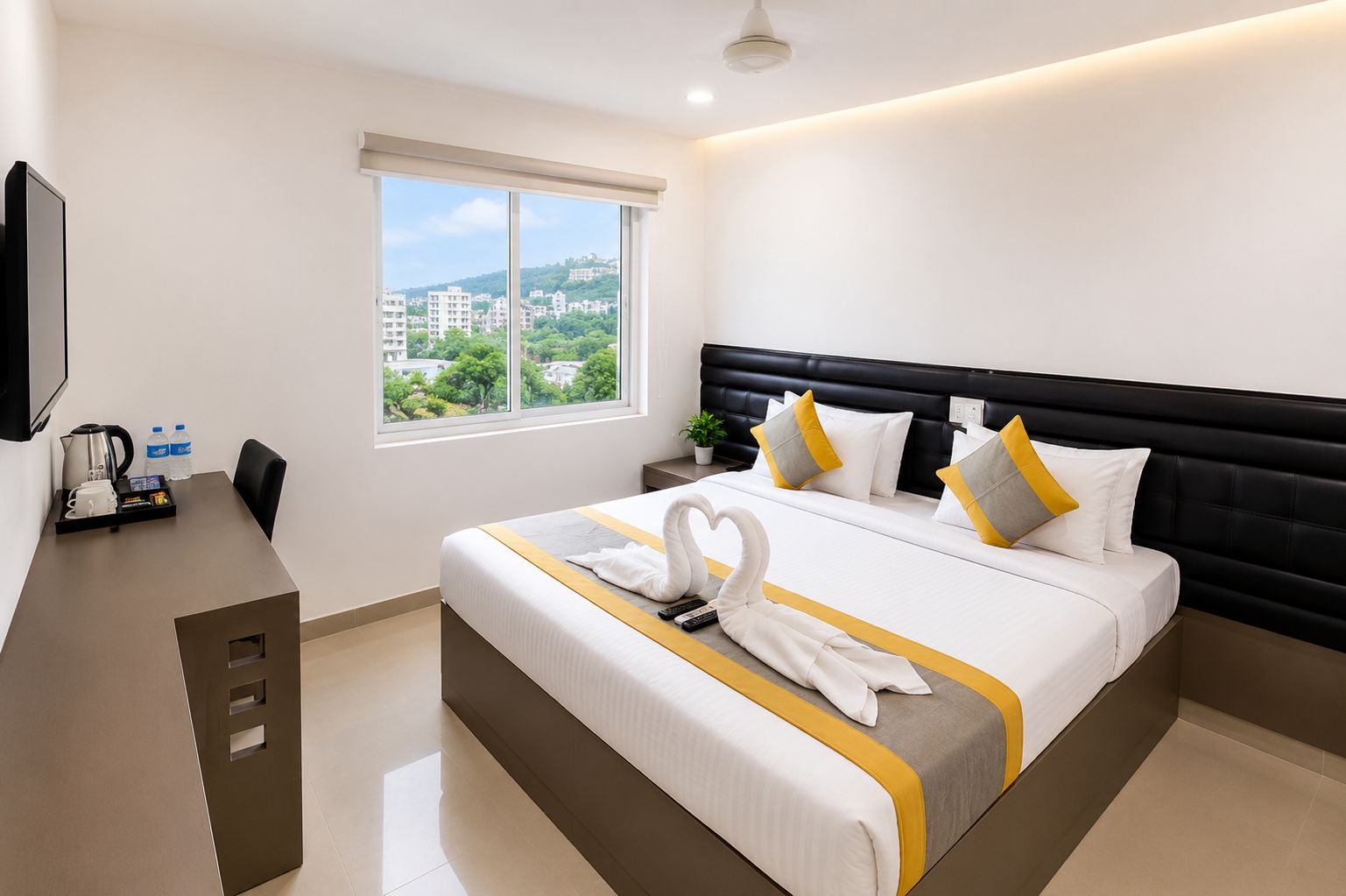 Habitación de hotel con una cama grande, un escritorio con cafetera y vistas a edificios a través de la ventana.