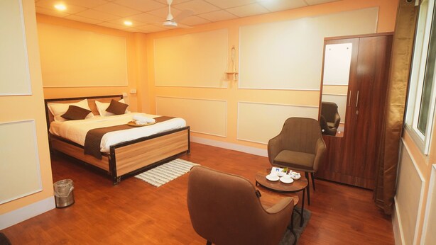 Una habitación de hotel con cama, una silla, una mesita y un armario.
