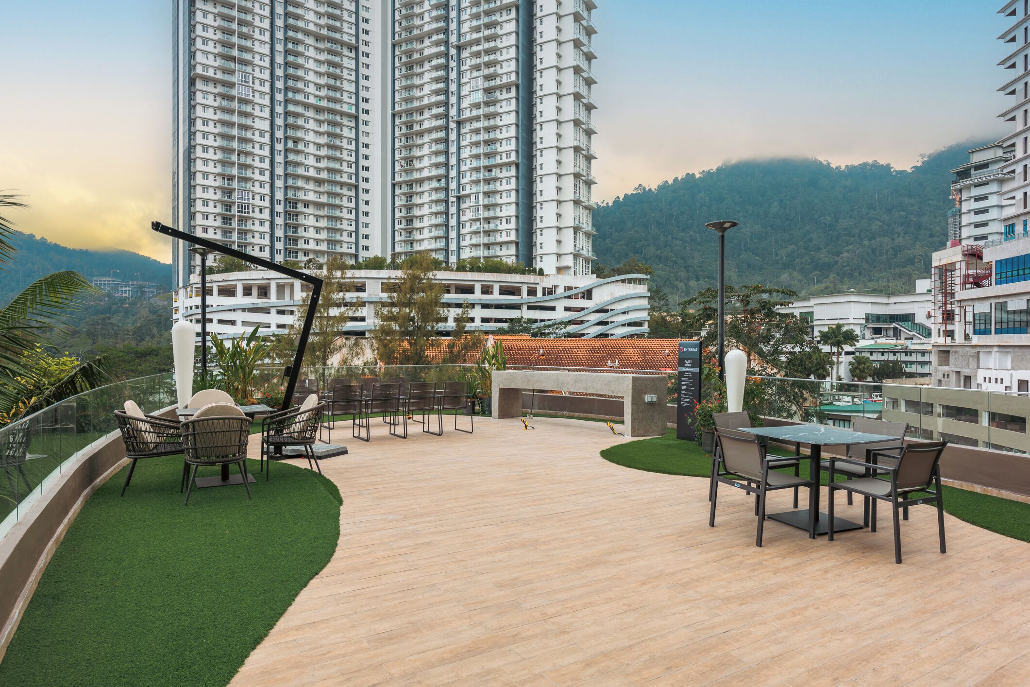 A rooftop terrace with a pool table, chairs, and a small garden area.
