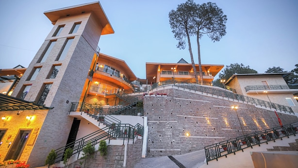 A multi-story hotel with a stone facade, multiple balconies, and a staircase leading to the upper levels.