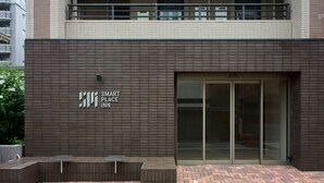 Un edificio con un letrero que dice 'SMART PLACE iNN' y una entrada de vidrio.