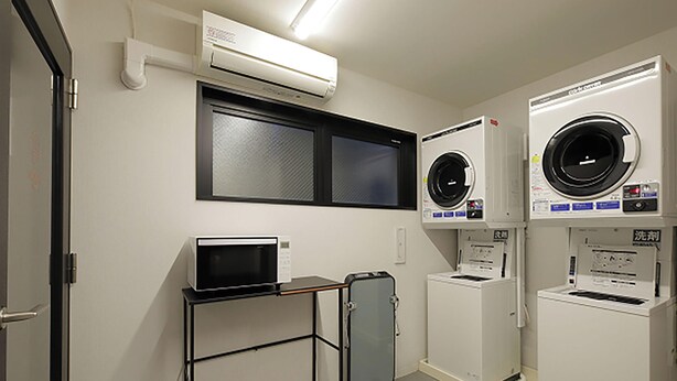 Una sala de lavandería con lavadora, secadora y un refrigerador pequeño.