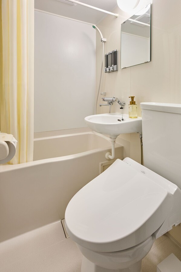 Une salle de bain avec des toilettes blanches, un lavabo et une baignoire.