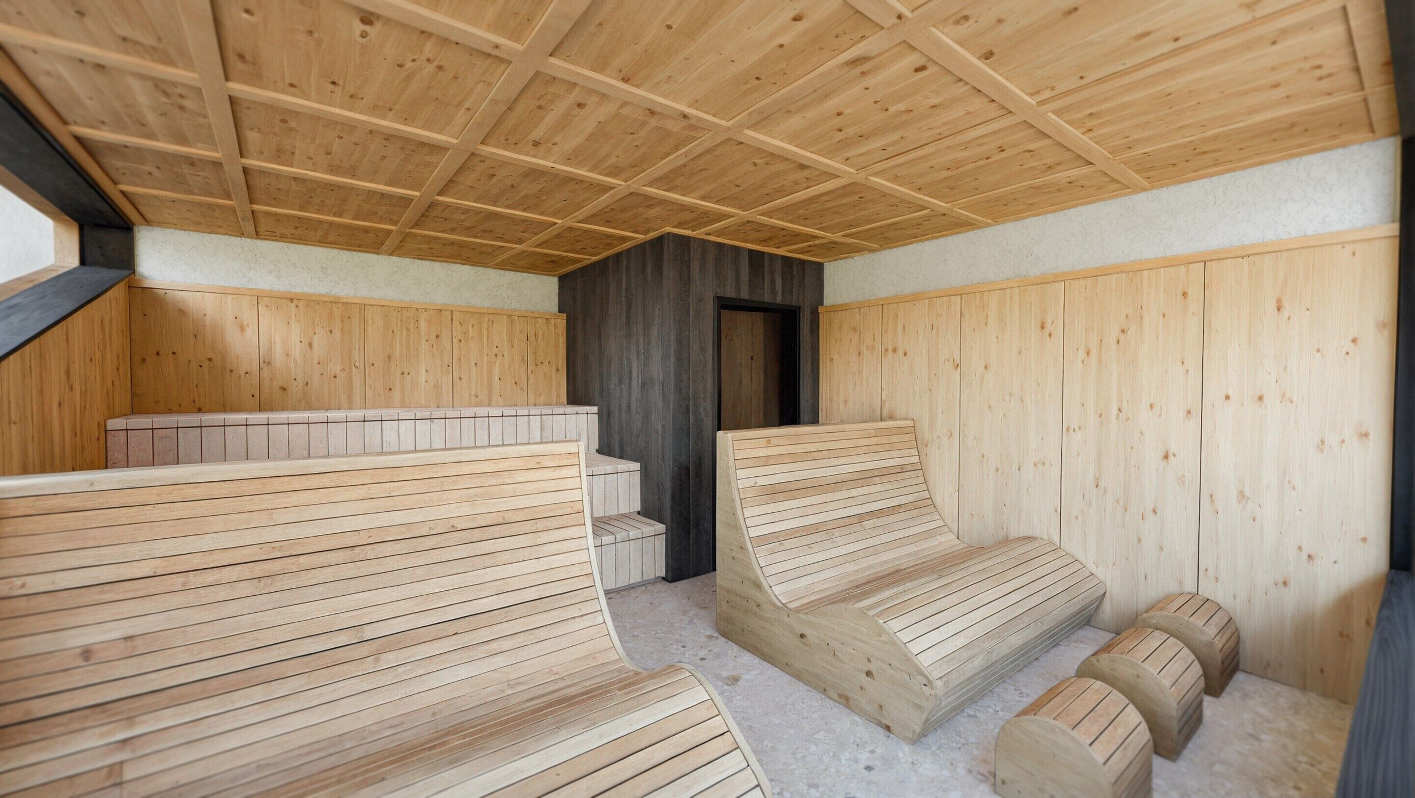 Uma sala de sauna com bancos de madeira e teto inclinado.