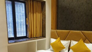 A hotel room with a bed, a window with curtains, a wooden headboard, and a textured wall panel. - Hotel Grand Palace Inn (Mumbai)