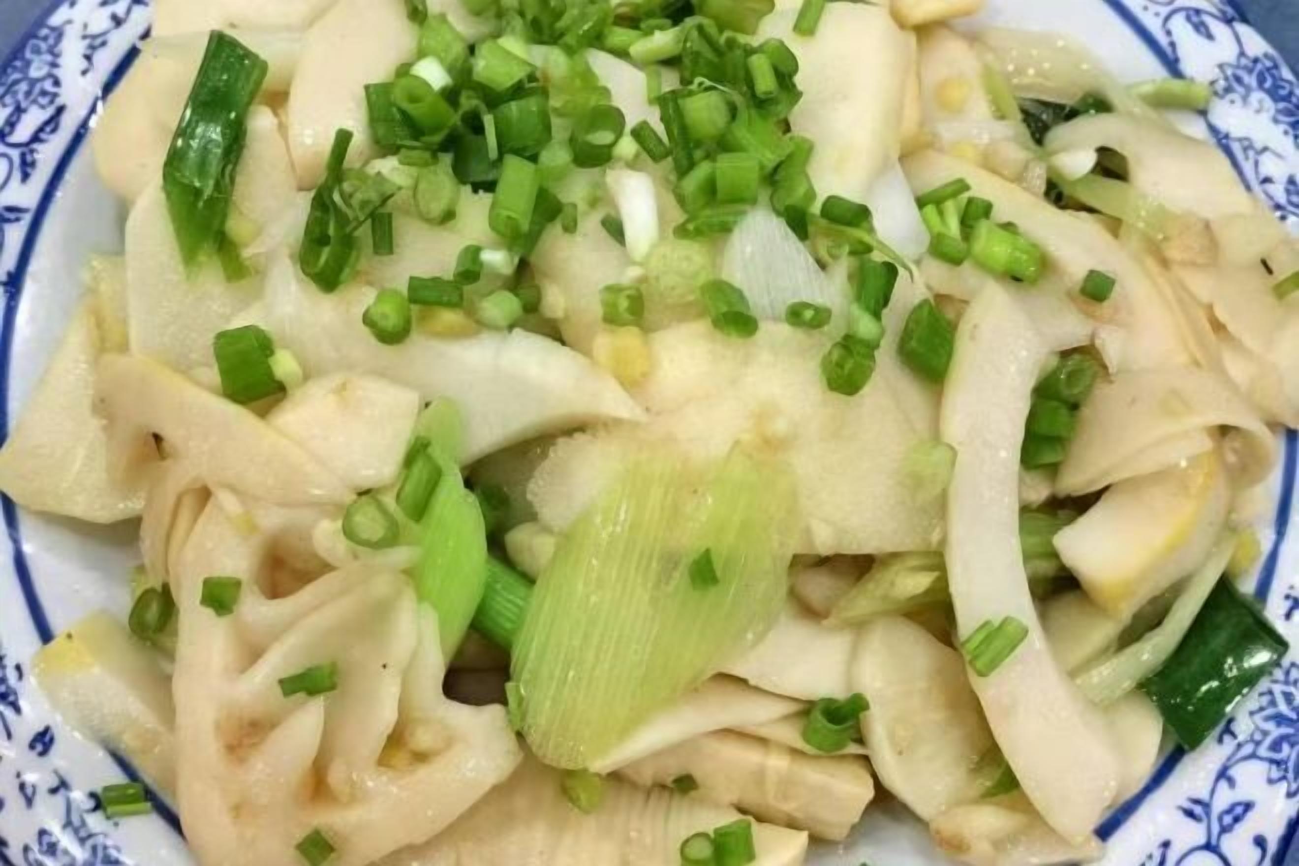 A plate of sliced white radish with green onions.