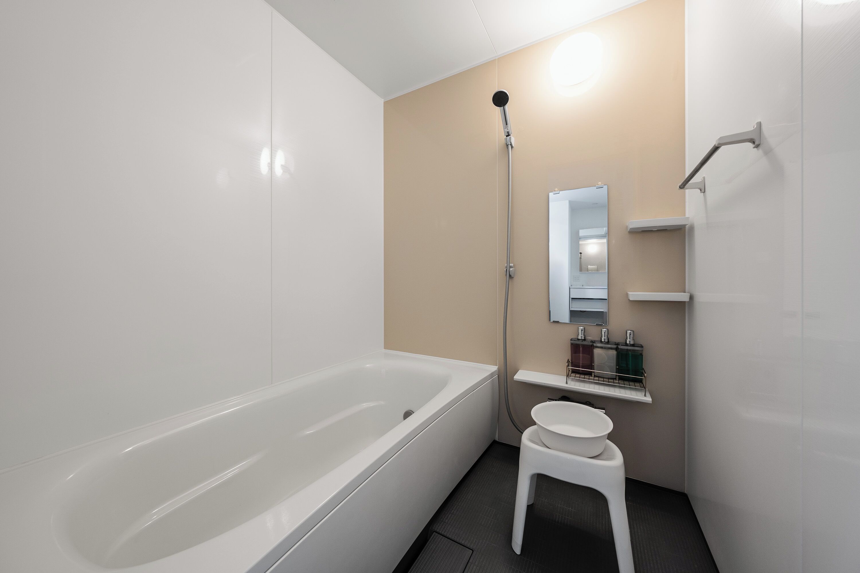 A modern bathroom with a bathtub, a shower, a sink, and a mirror.