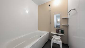 A modern bathroom with a bathtub, a shower, a sink, and a mirror.