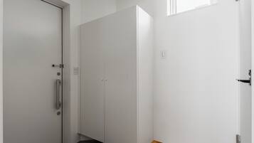A room with a wooden floor, white walls, and a door with a handle.