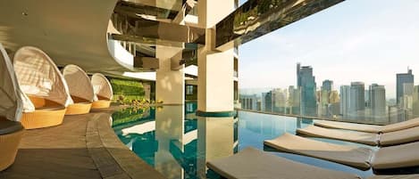 Uma área de piscina moderna no terraço, com espreguiçadeiras e vista para a cidade.